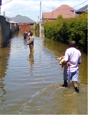 Des habitants traversent les eaux pour récupérer des objets dans leurs maisons inondées à Bujumbura, Quartier Kinindo, Mars 2024.