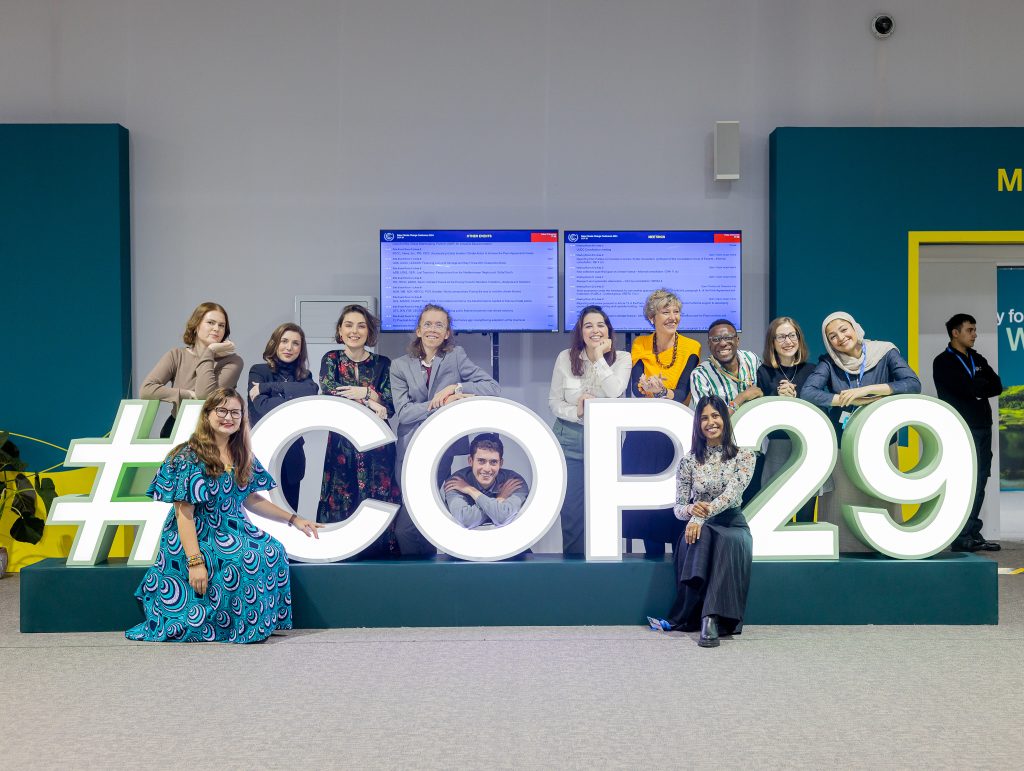 Climate Youth Negotiator Participants at COP29, in front of COP29 sign.